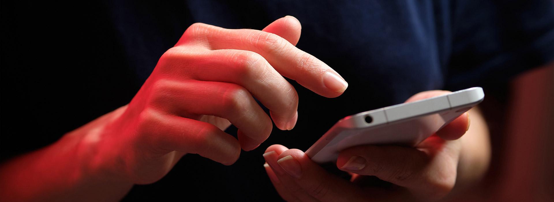 Male hand performing a transaction on a cell phone