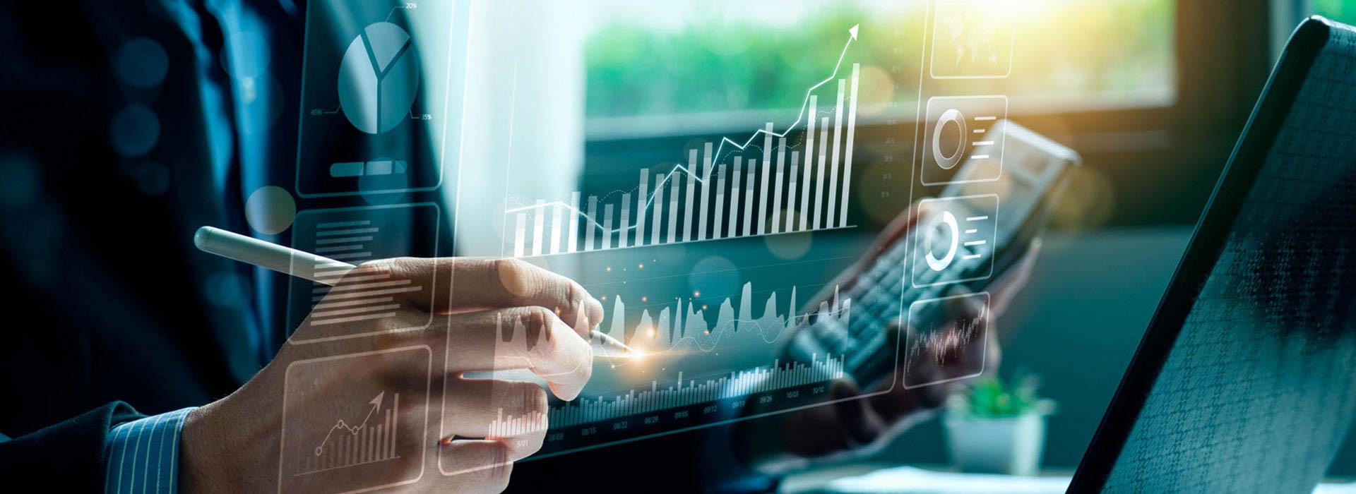 man in front of laptop holding calculator and pen