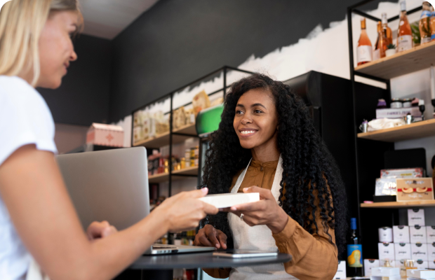 Woman handing cashier product she intends to purchase