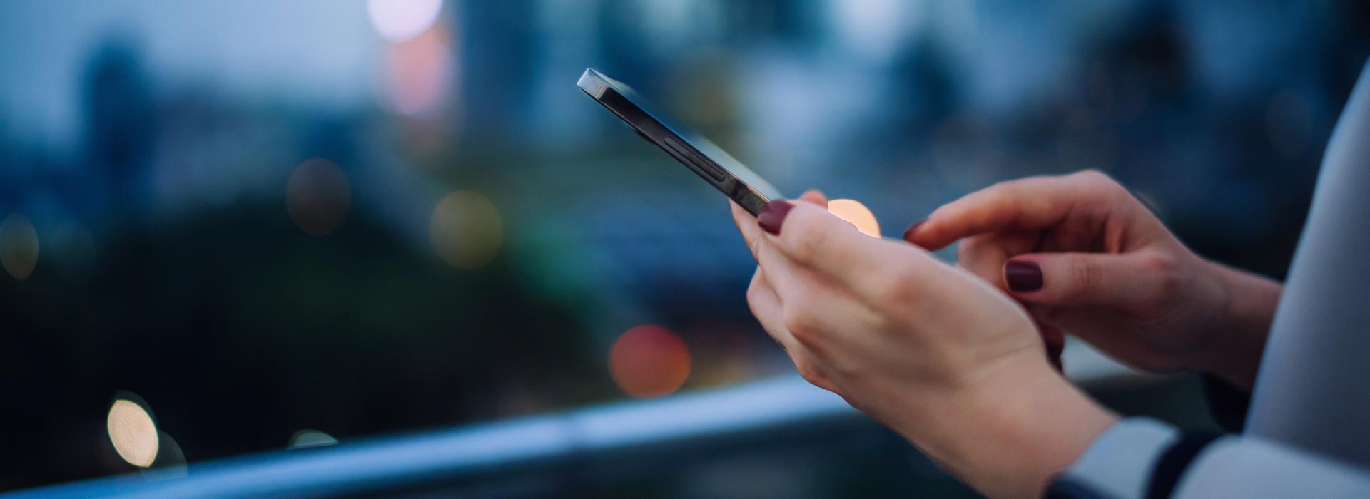 Cell phone transaction in woman's hand (blue background)