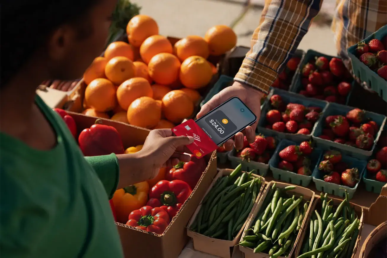 Paying using tap on an iphone with a credit card at a fruitstand