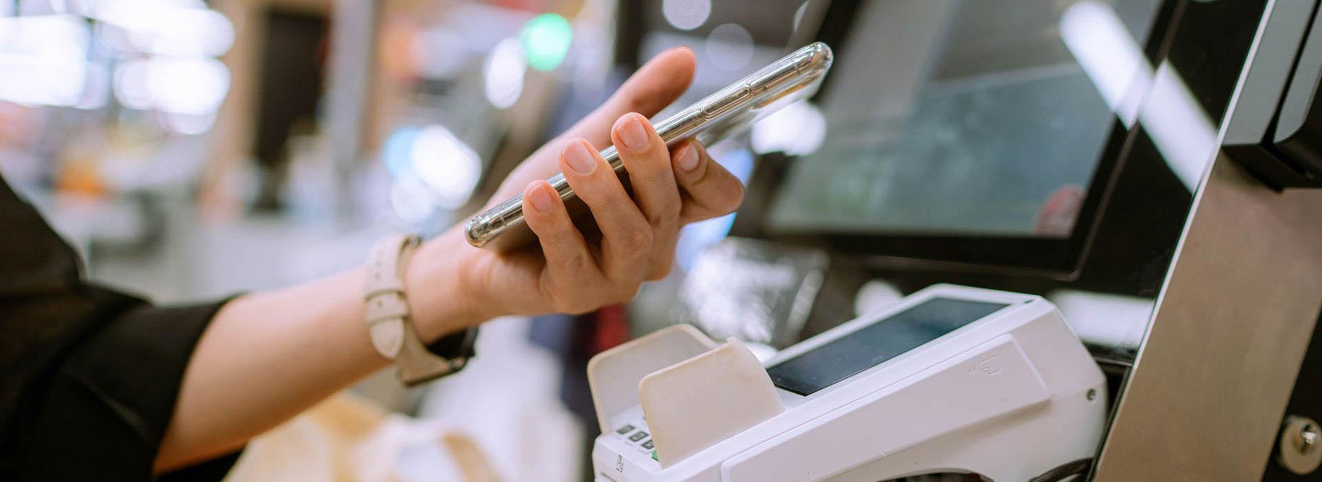 Woman's hand holding cell phone over processor