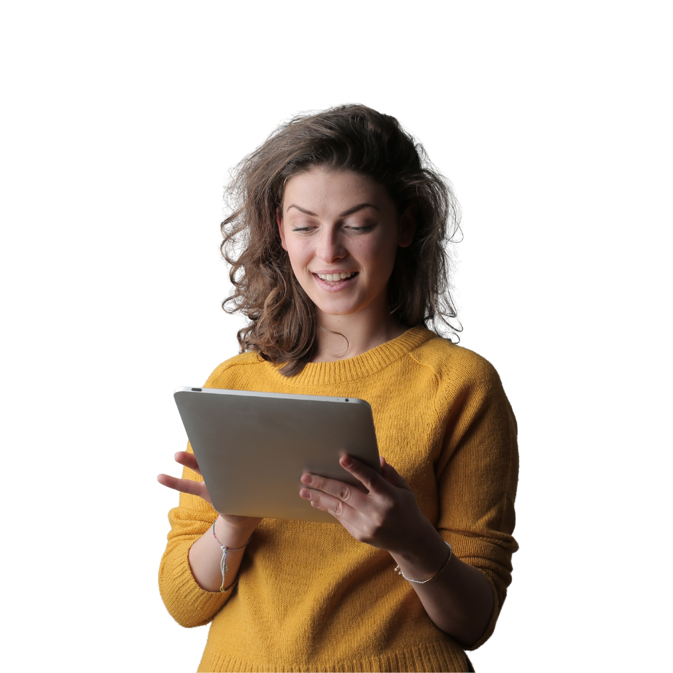 Woman in yellow sweater smiling while holding and looking at a tablet device against white background.