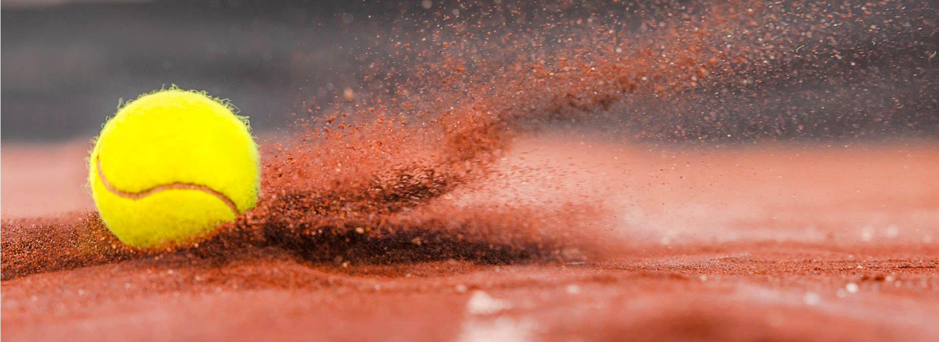 Tennis ball hitting clay dirt