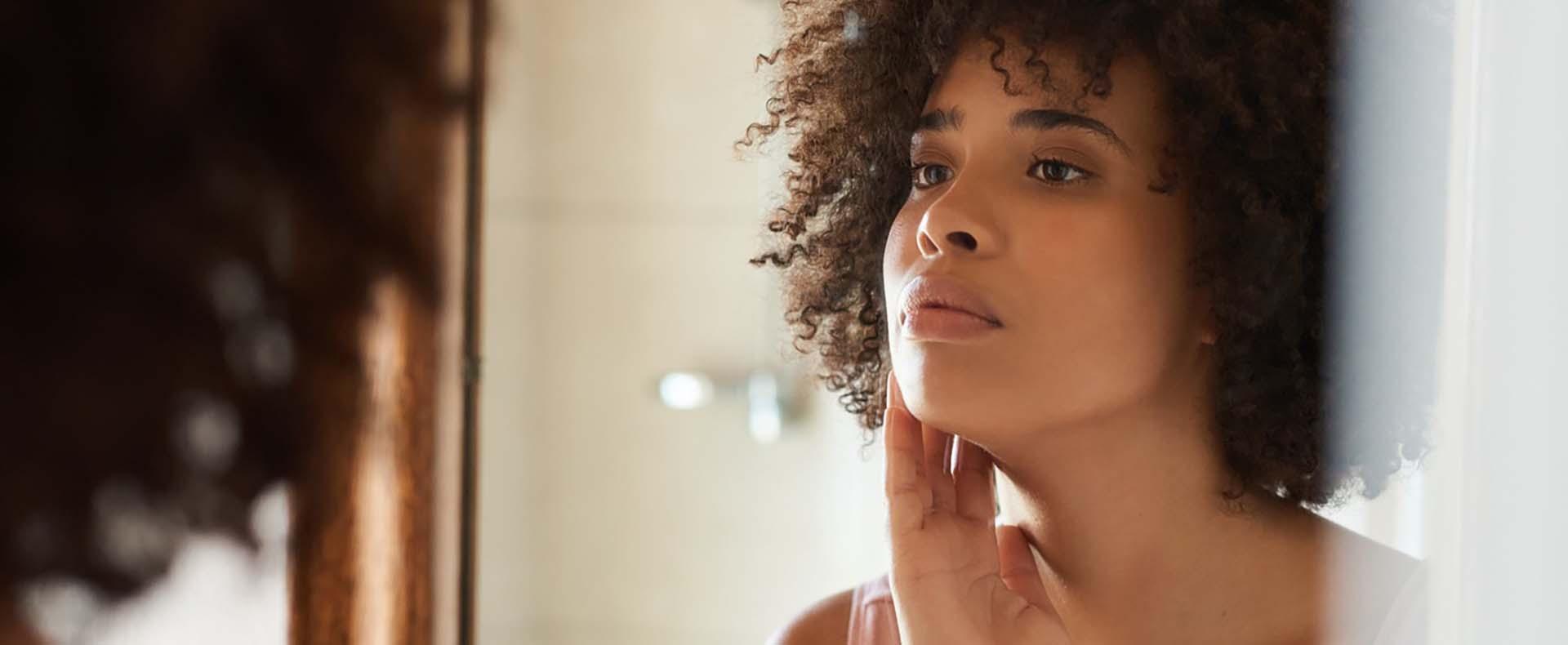 Biracial woman looking in mirror